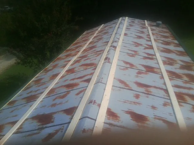 Rusted metal roof panels with new wood purlins before replacement — Storm Damage Roof Repair in Wingina by Roofing Brothers