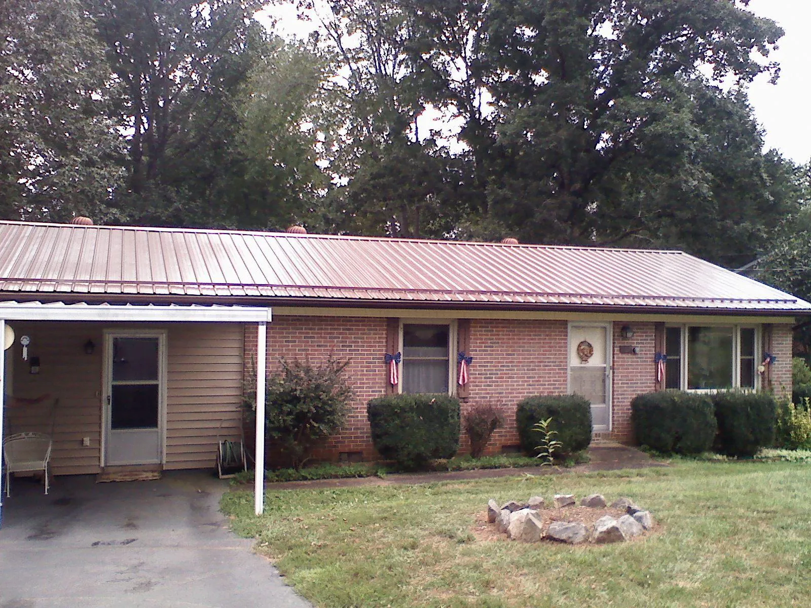 Bronze metal roof and carport on a brick ranch home — Roof Repair work by our crew in Wingina