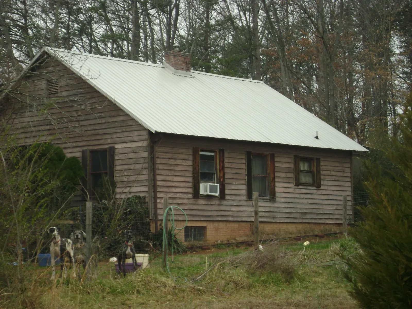 White metal roof on an old wood sided farmhouse, from a Metal Roof Installation job in Wingina